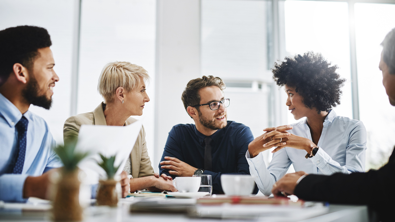 Cropped shot of a diverse group of businesspeople sitting together and having a meeting in the office